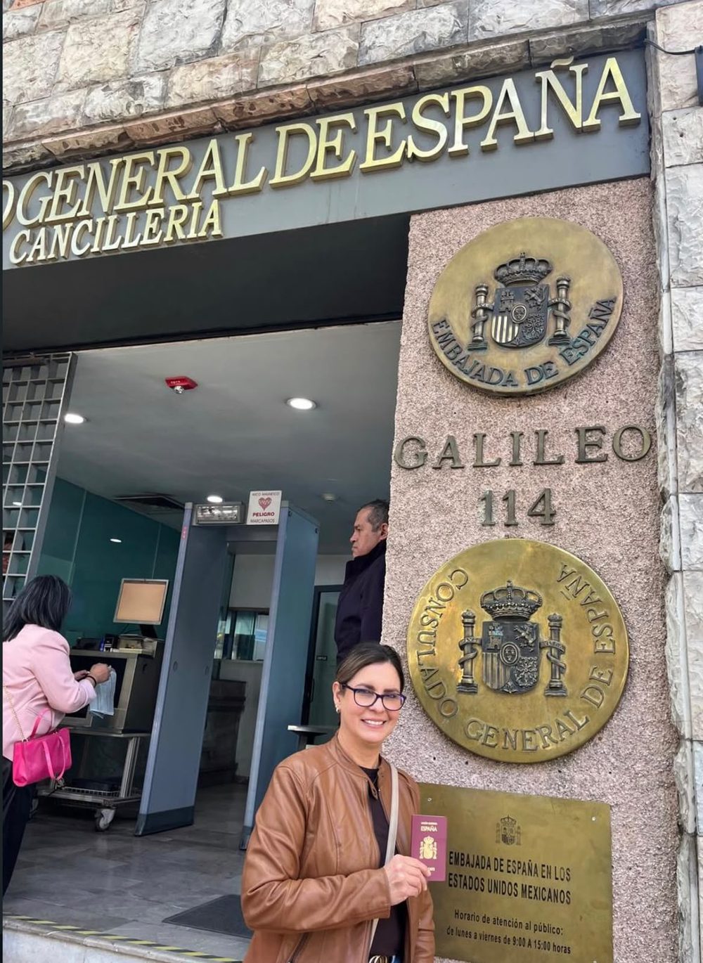 Client holding a Spanish passport in front of the Consulate General of Spain